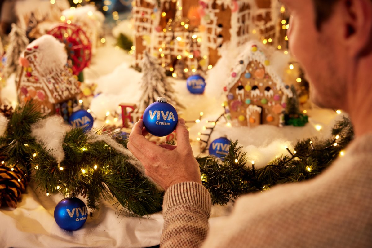 Ein Mann freut sich über den Anblick einer blauen Weihanchtskugel von VIVA Cruises